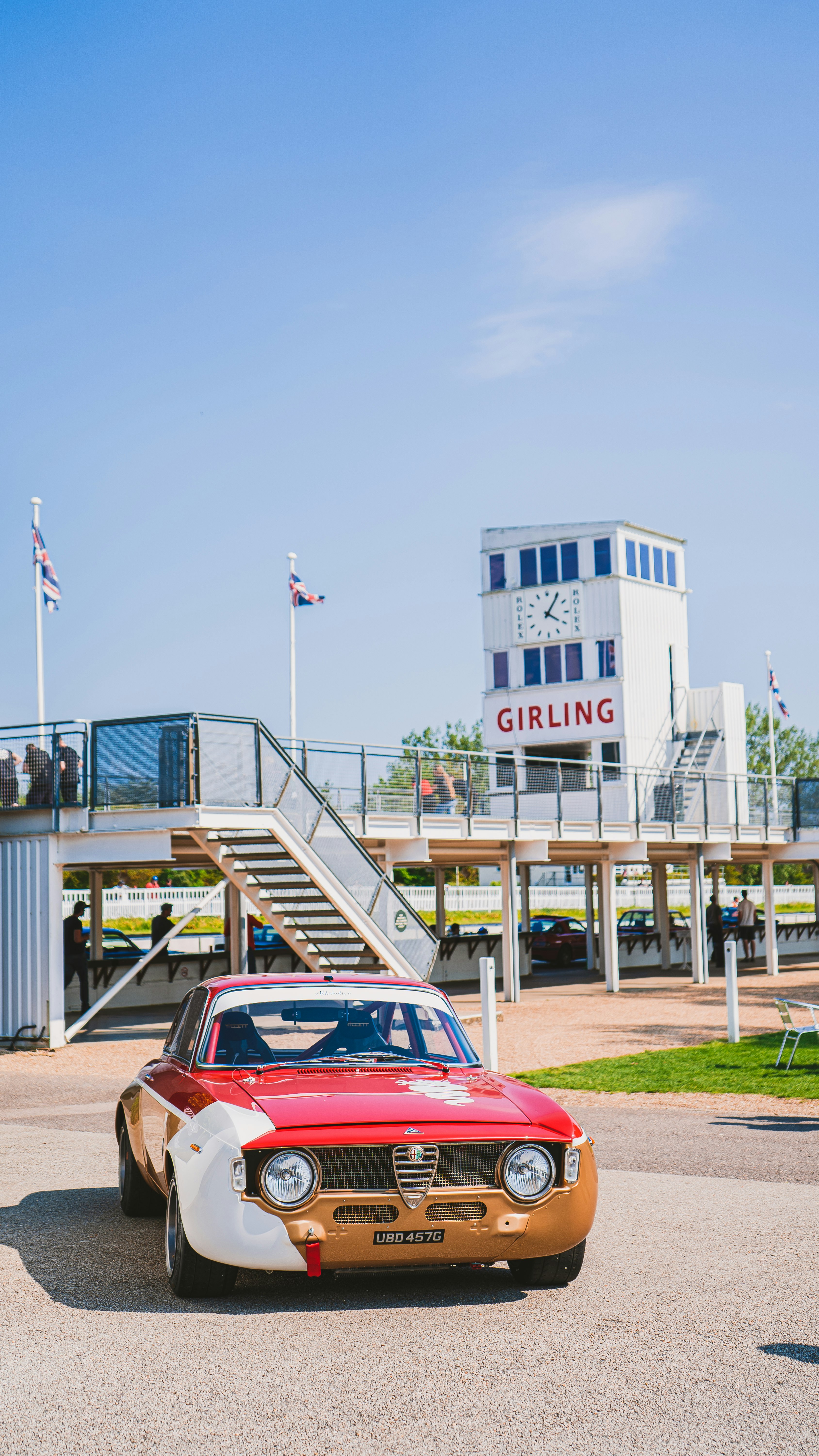 red car parked near white and blue building during daytime